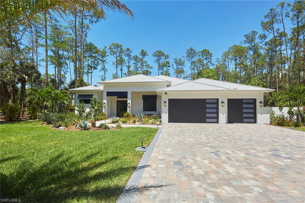 5301 Tamarind Ridge Drive Naples, FL 34119 - Photo 9 of 50 a front view of a house with a yard table and chairs