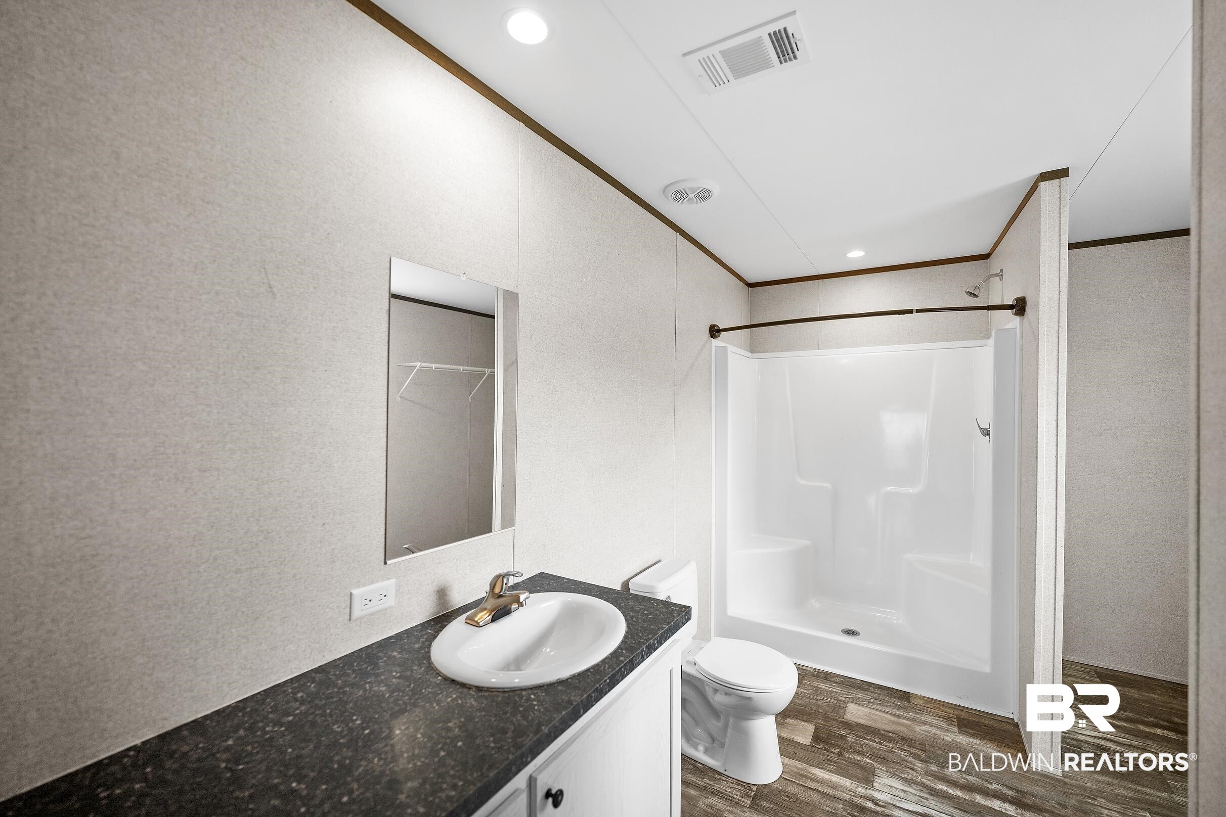 21601 Westside Loop Silverhill, AL 36576 - Photo 22 of 42 Bathroom featuring a single vanity with dark countertop, white oval sink, and chrome faucet