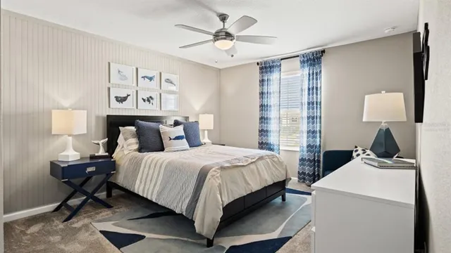 a bedroom with a bed a computer on a desk and chair