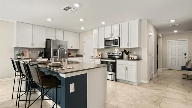 a kitchen with a sink a microwave a refrigerator and cabinets