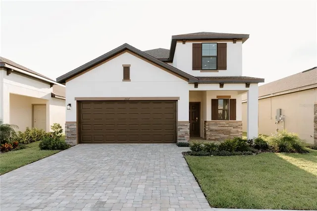 a front view of a house with a yard and garage