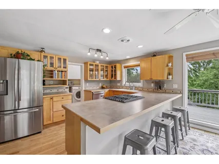 a kitchen with kitchen island a large counter top space appliances and windows