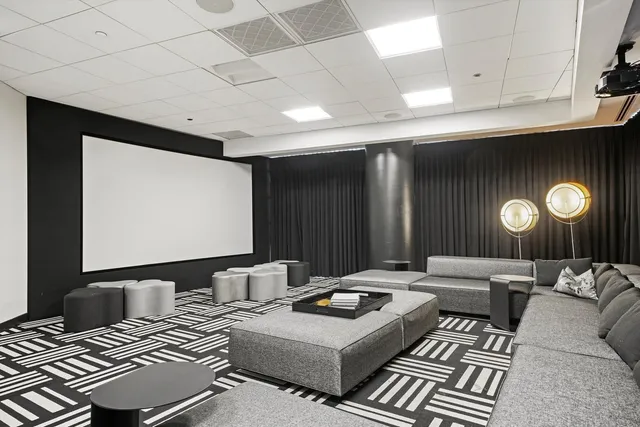 a living room with furniture a flat screen tv and kitchen view