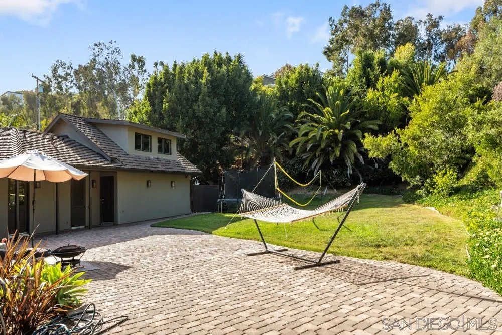 16919 Reposa Alta Rancho Santa Fe, CA 92067 - Photo 44 of 51 a view of a backyard with a table and chairs under an umbrella