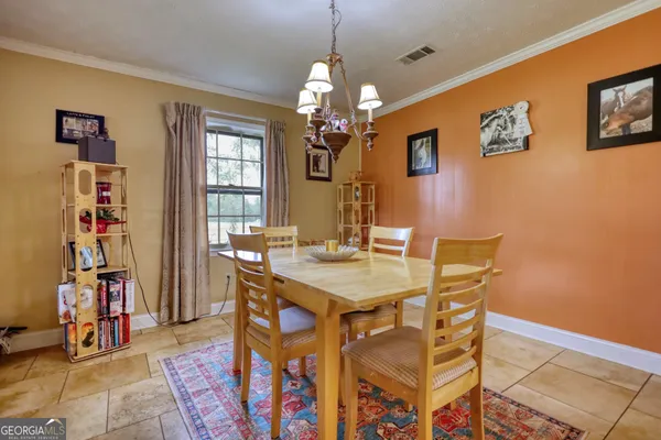 a view of a dining room with furniture and chandelier
