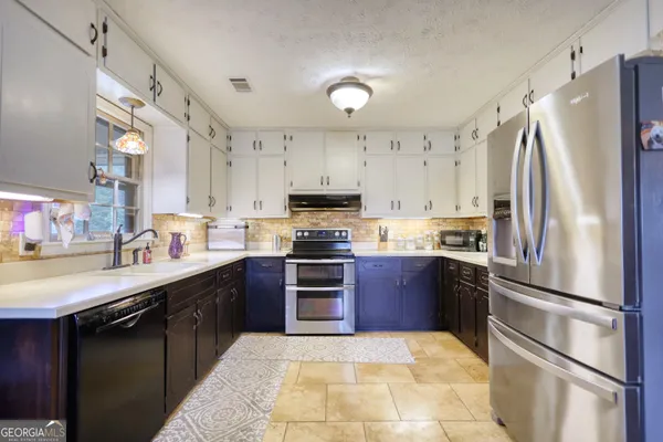 a kitchen with stainless steel appliances granite countertop a refrigerator stove and sink