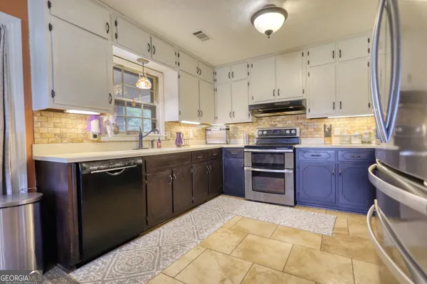a kitchen with stainless steel appliances granite countertop a stove sink and cabinets