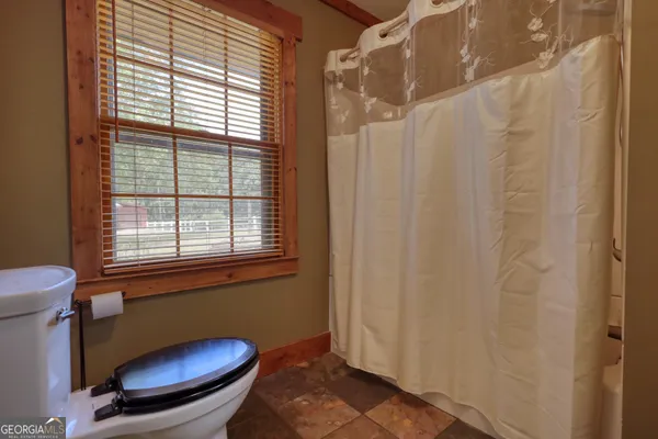 a bathroom with a toilet and a window