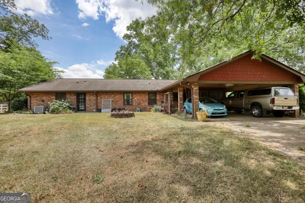 a front view of a house with a yard and trees