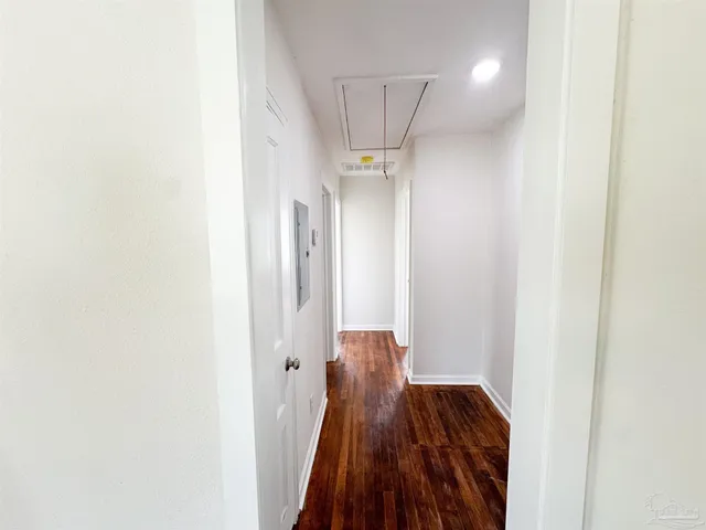 a view of a hallway with wooden floor and staircase