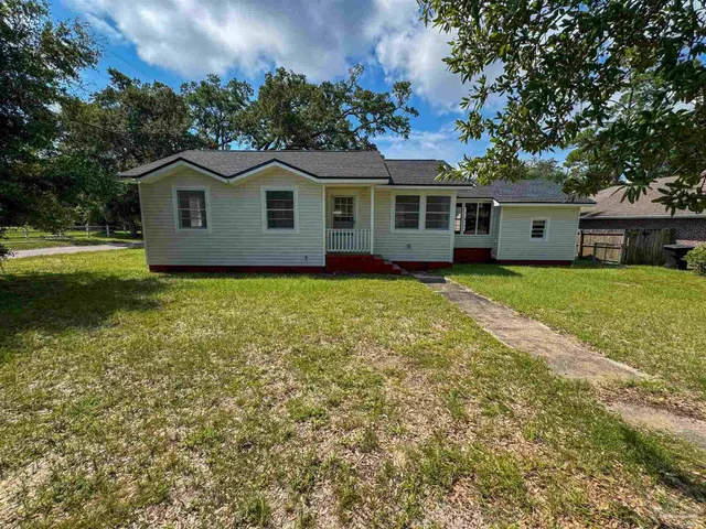 a front view of a house with yard and green space