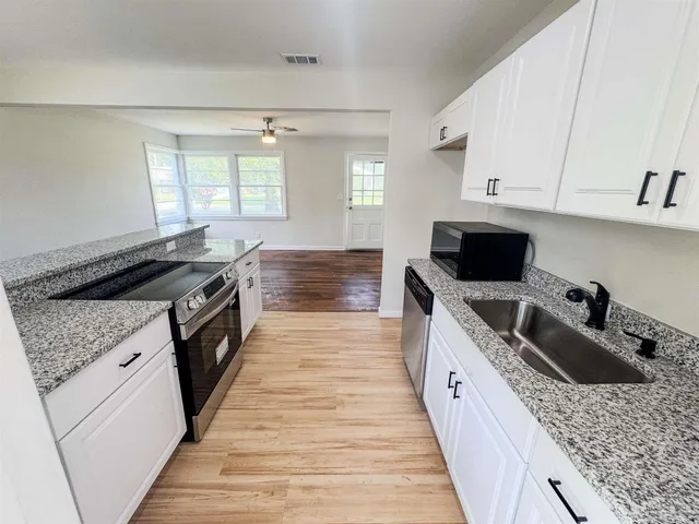 a kitchen with a stove sink and cabinets