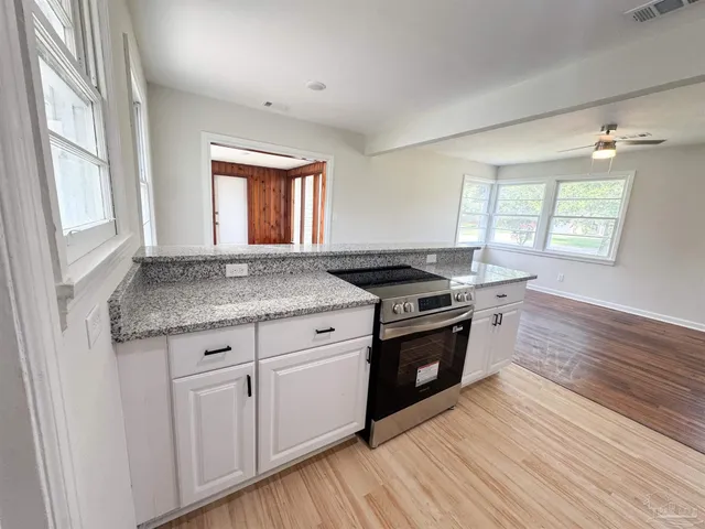 a kitchen with granite countertop a stove and a sink