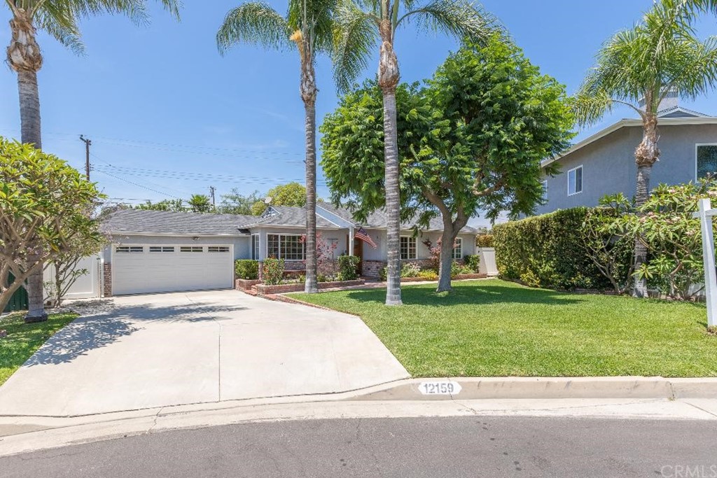 front view of house with a yard and potted plants