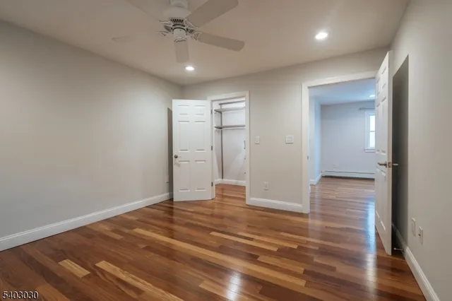 a view of an empty room with wooden floor