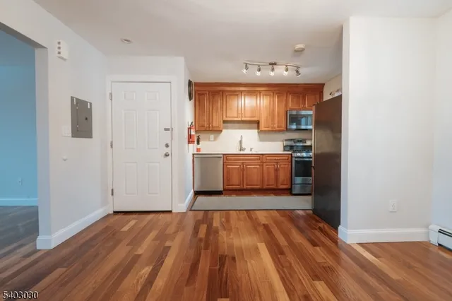 a view of a kitchen with wooden floor and electronic appliances