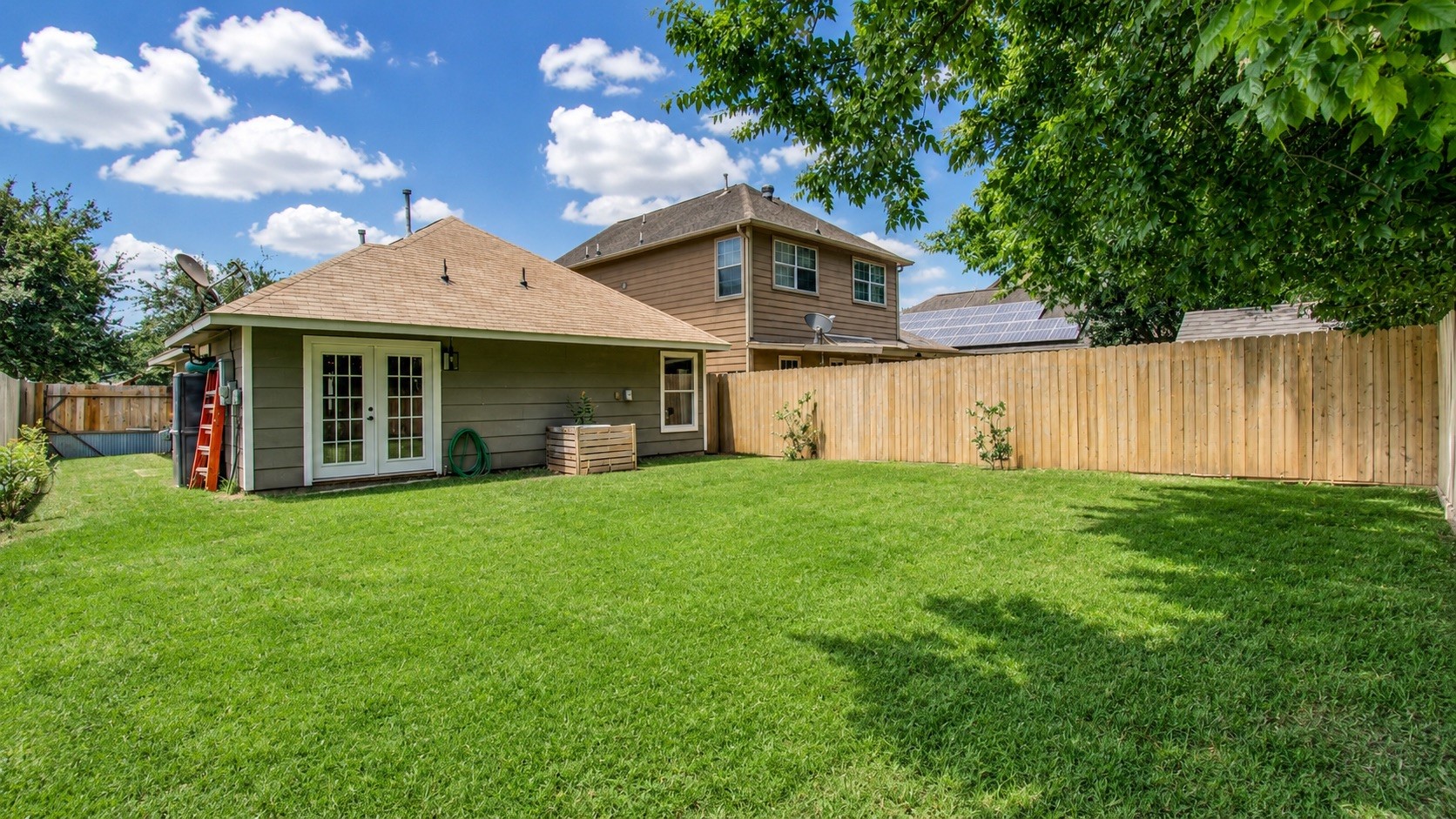 8647 Suburban Oaks Road Houston, TX 77093 - Photo 19 of 21 A patio edge and green lawn create a simple outdoor setting along the rear elevation. (photo has been enhanced for marketing purposes)