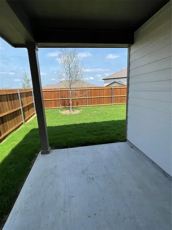 a view of a yard with a wooden fence