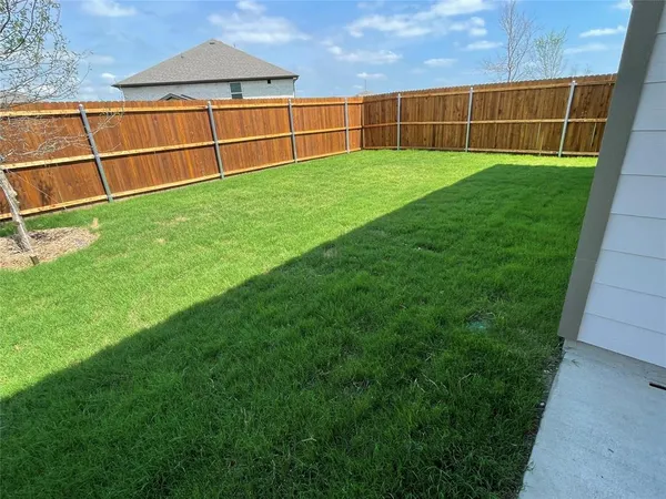 a view of a yard with wooden fence