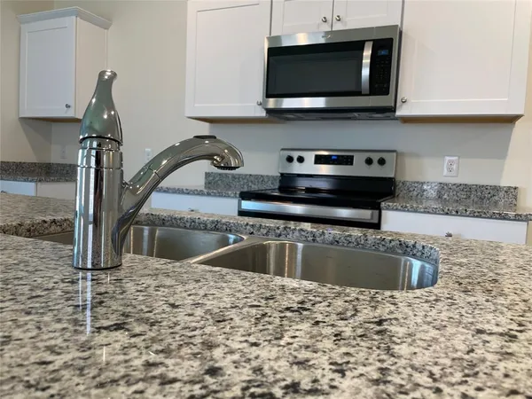 a kitchen with a sink stove and microwave