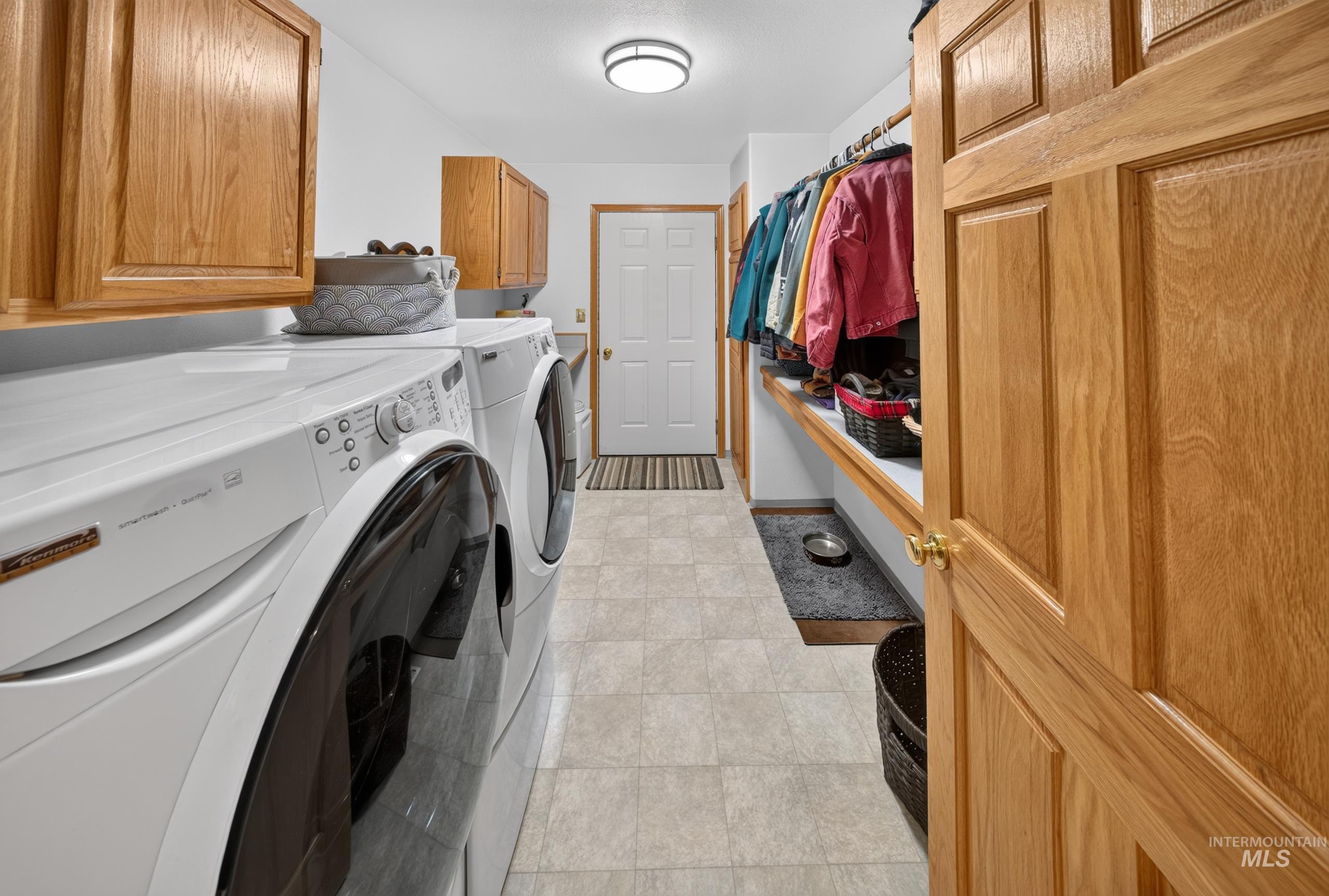 5540 Finley Road Fruitland, ID 83619 - Photo 36 of 50 Utility area with tiled flooring, built-in shelving, cabinetry, and a full-size front-loading washer and dryer