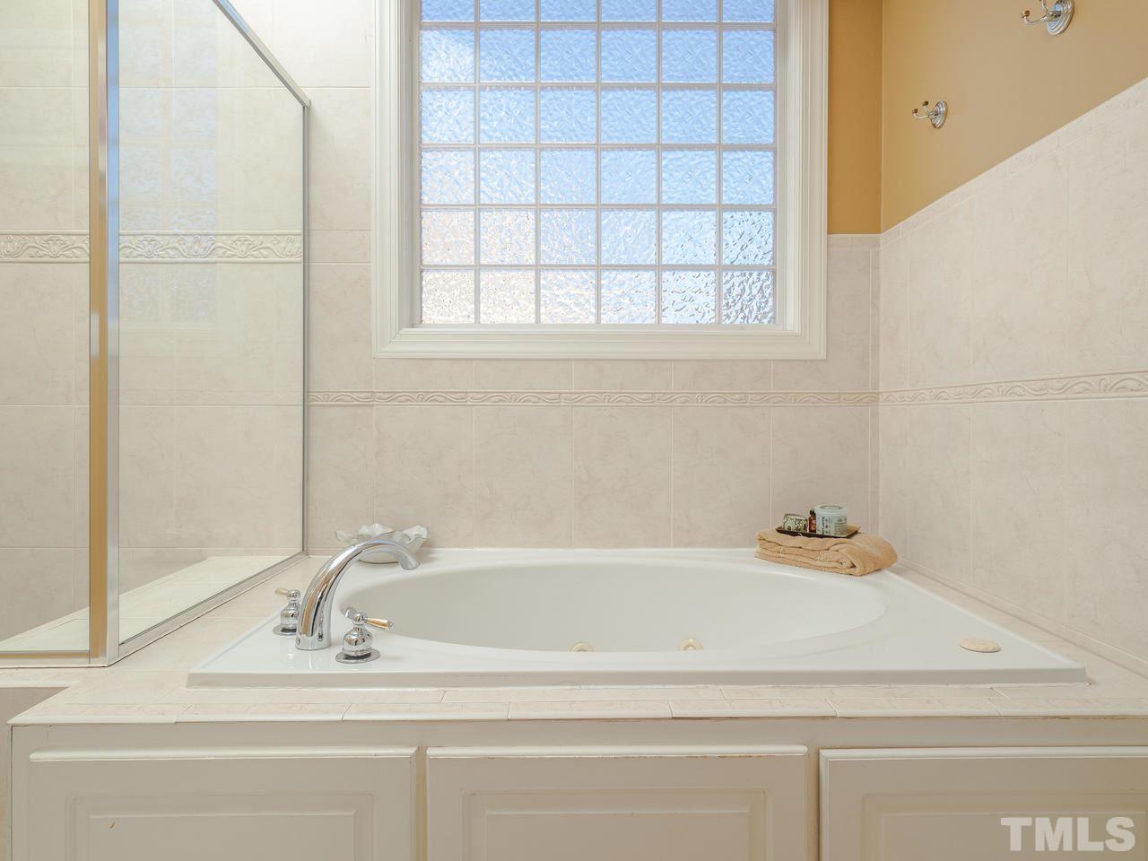 4604 Whitmire Place Raleigh, NC 27612 - Photo 16 of 25 a bathroom with a bathtub and window