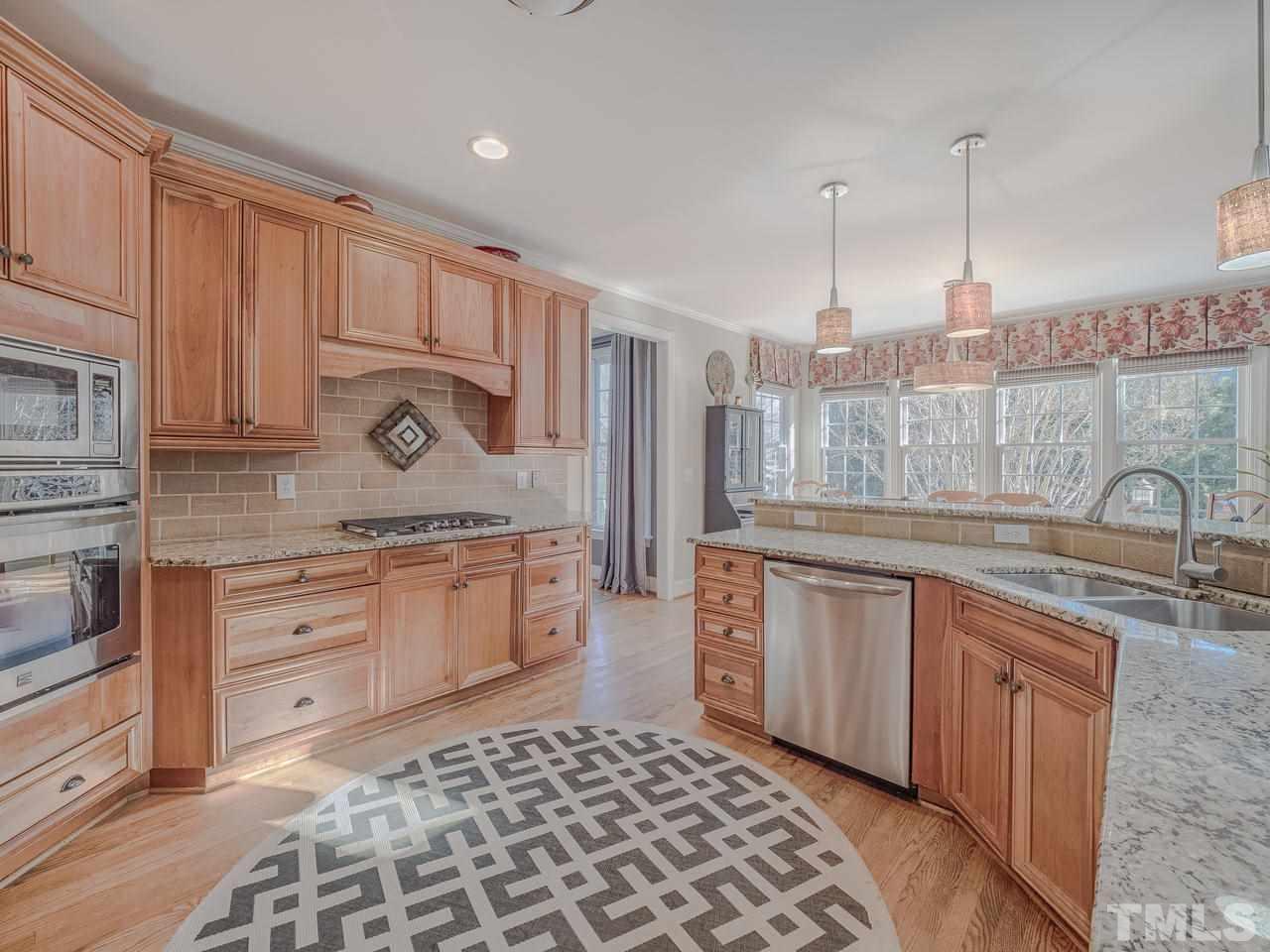 4604 Whitmire Place Raleigh, NC 27612 - Photo 7 of 25 a kitchen with stainless steel appliances granite countertop a sink and cabinets