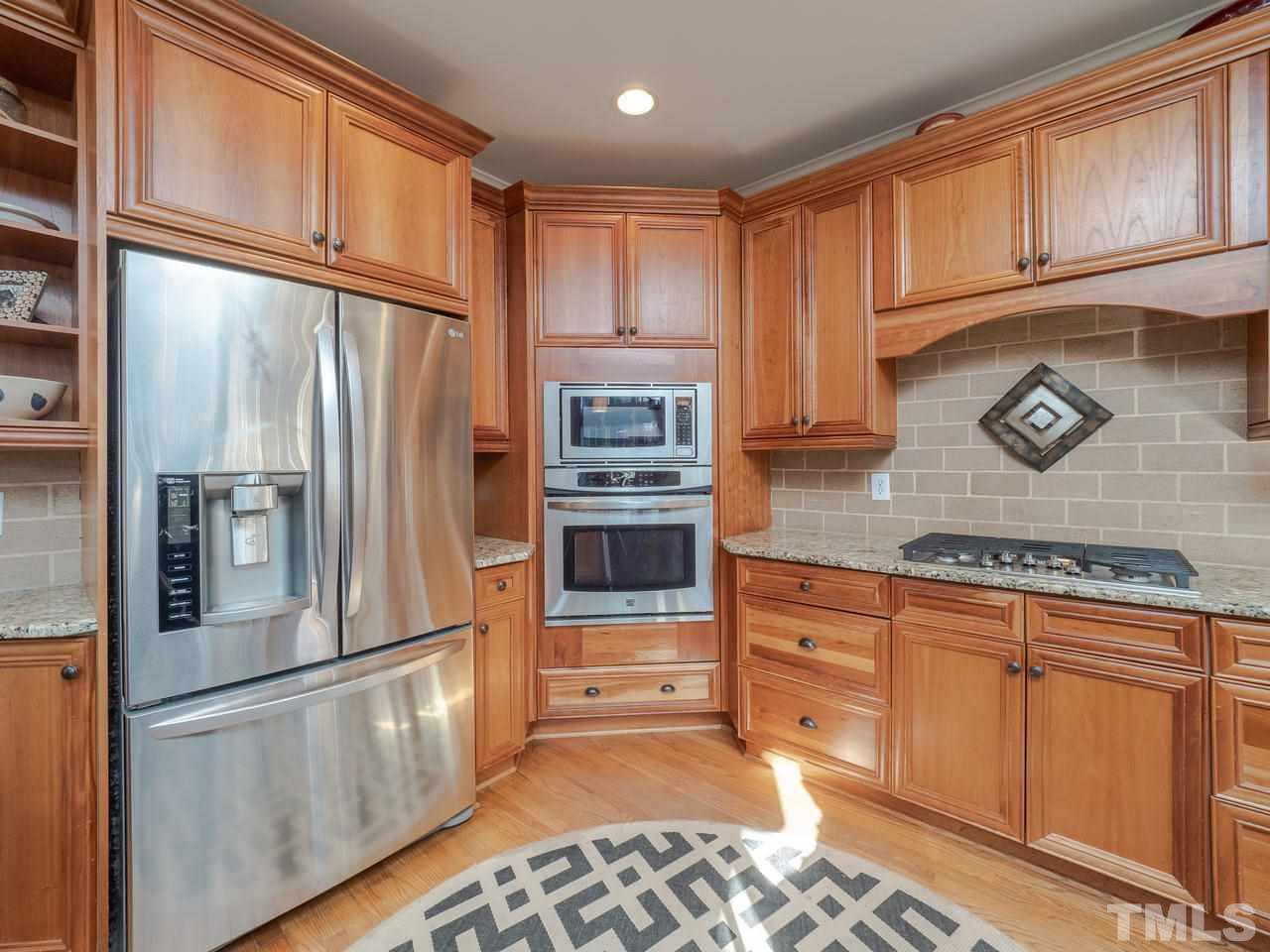 4604 Whitmire Place Raleigh, NC 27612 - Photo 8 of 25 a kitchen with stainless steel appliances granite countertop a refrigerator a stove and a sink