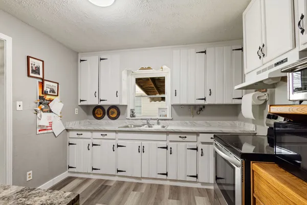 a kitchen with granite countertop a sink and cabinets