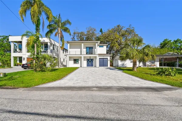 a front view of a house with a yard and potted plants