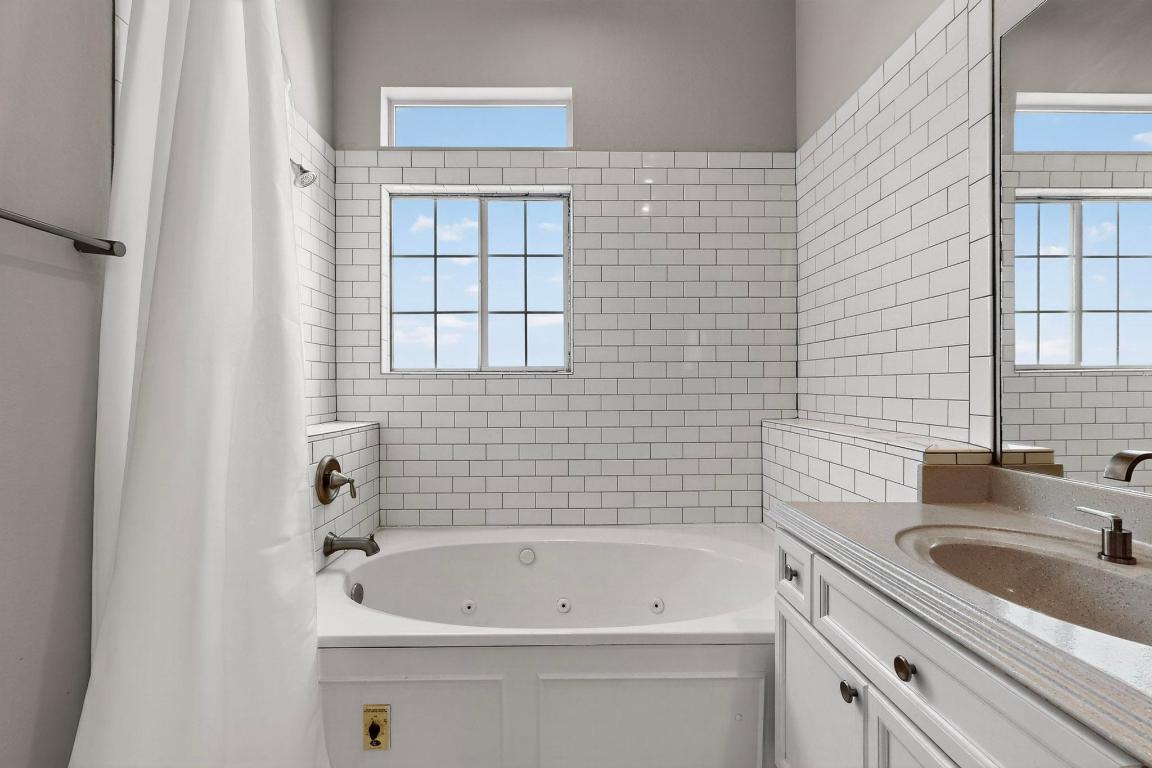 2918 Ranch Road 620 North, Unit T250 Austin, TX 78734 - Photo 12 of 22 a bathroom with a sink a bathtub and next to a window
