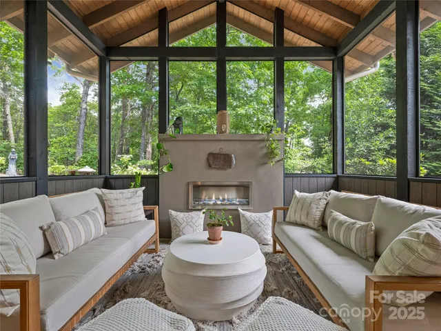 a living room with furniture a large window and a fireplace