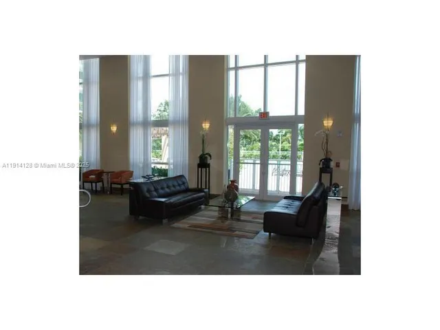 a living room with furniture and large windows