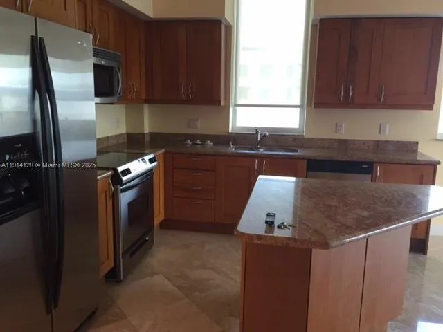 a kitchen with stainless steel appliances granite countertop a refrigerator a stove a sink and dishwasher