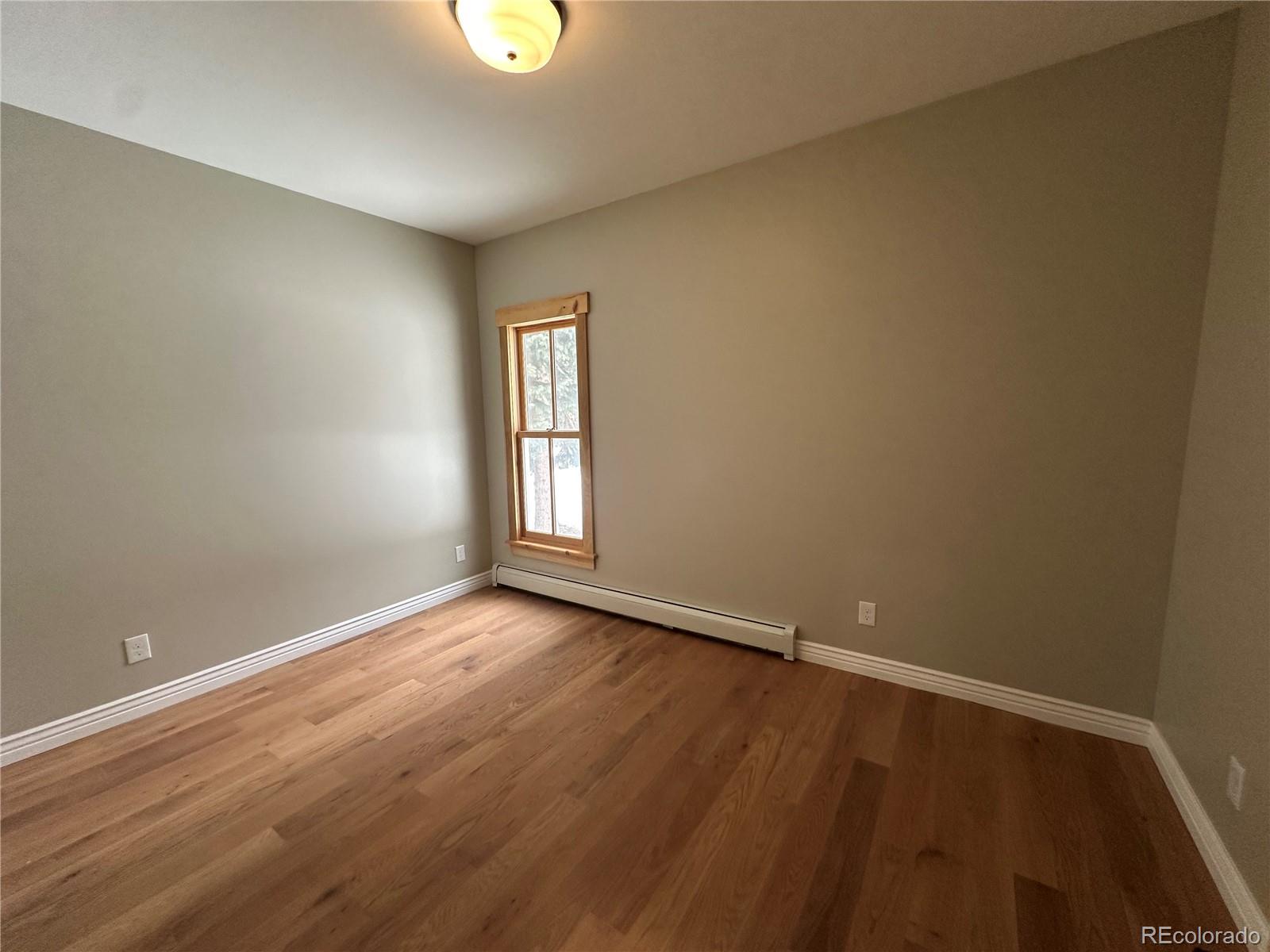 902 Rose Street Georgetown, CO 80444 - Photo 12 of 23 a view of an empty room with wooden floor and a window