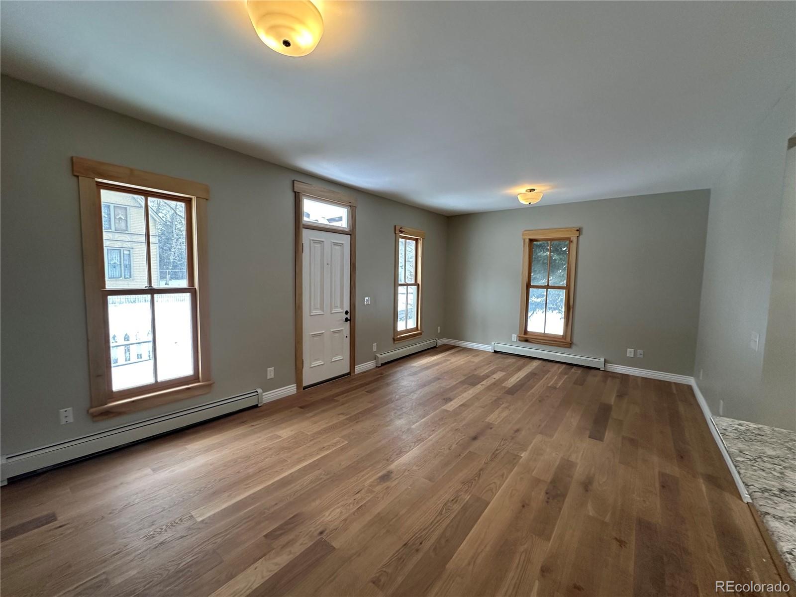 902 Rose Street Georgetown, CO 80444 - Photo 22 of 23 an empty room with wooden floor and windows