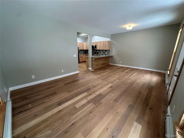a view of empty room with wooden floor