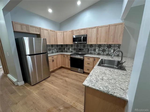a kitchen with stainless steel appliances granite countertop a refrigerator stove microwave and sink