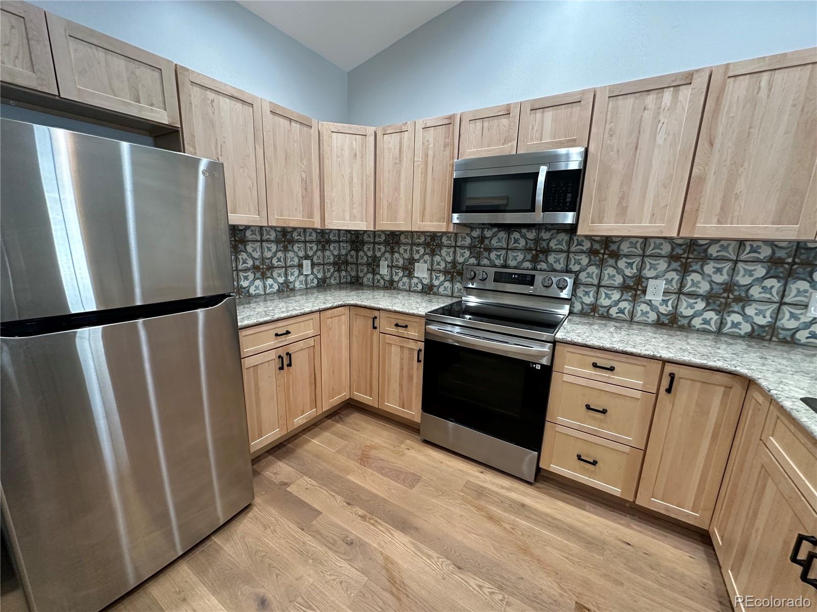 902 Rose Street Georgetown, CO 80444 - Photo 9 of 23 a kitchen with granite countertop a refrigerator stove and microwave