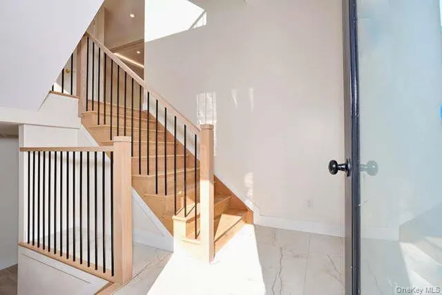 a view of staircase with railing and white walls