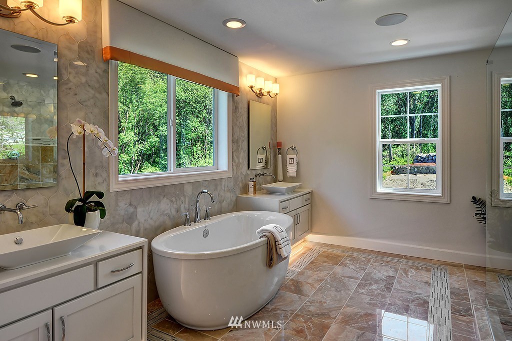 9911 Northeast 158th Street Bothell, WA 98011 - Photo 14 of 25 a bathroom with a tub sink and mirror