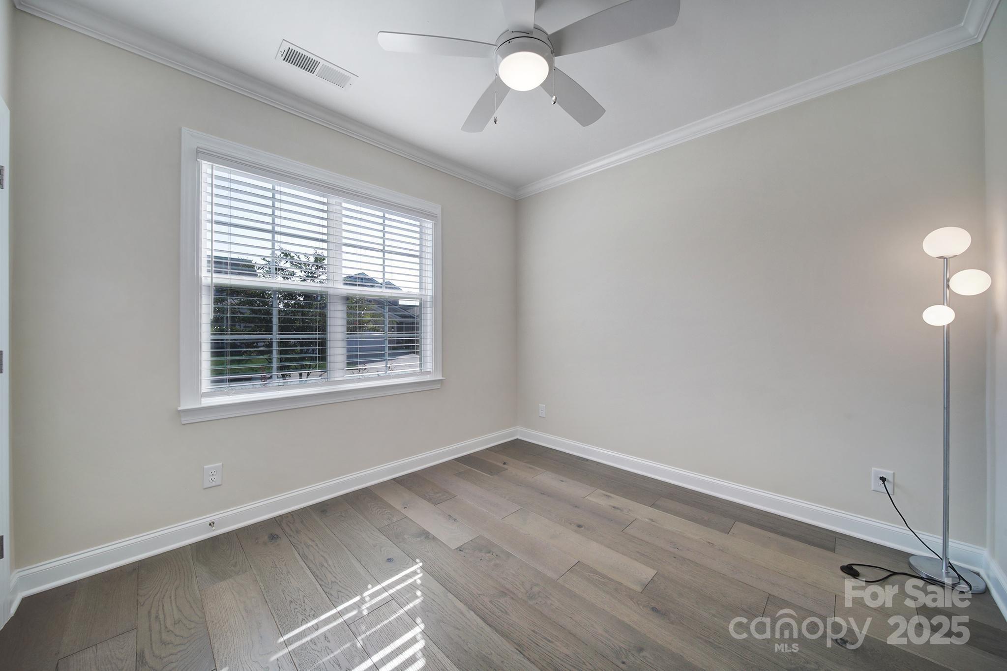 6255 Scuttle Lane, Unit 1104 Denver, NC 28037 - Photo 18 of 45 a view of an empty room with wooden floor and a window