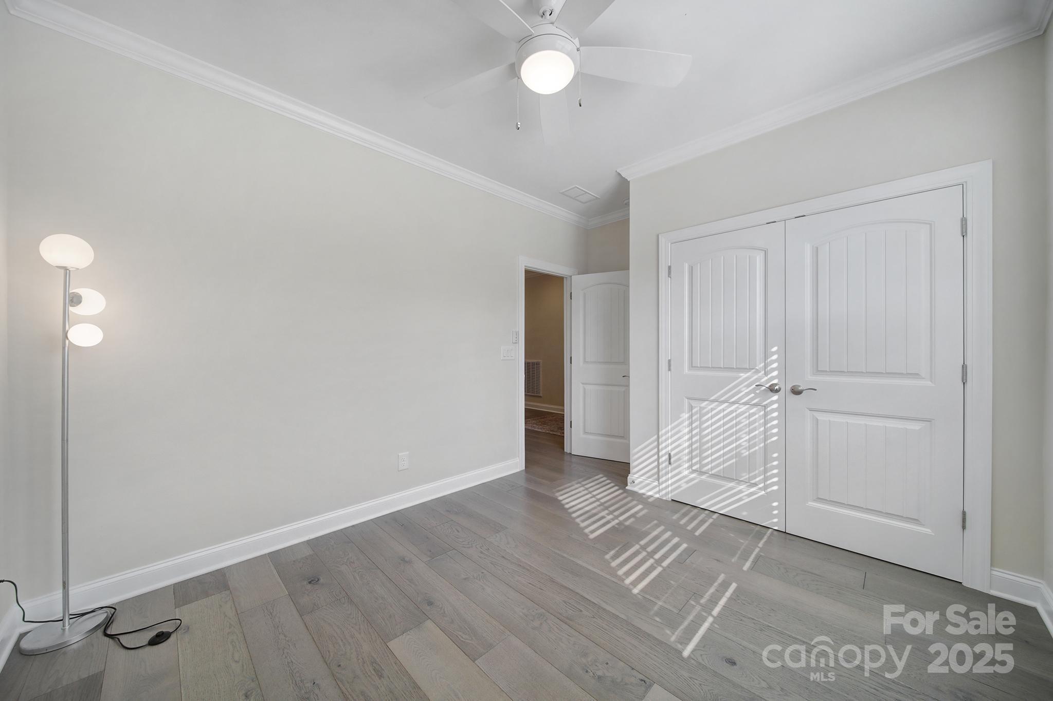 6255 Scuttle Lane, Unit 1104 Denver, NC 28037 - Photo 19 of 45 an empty room with wooden floor and ceiling fan