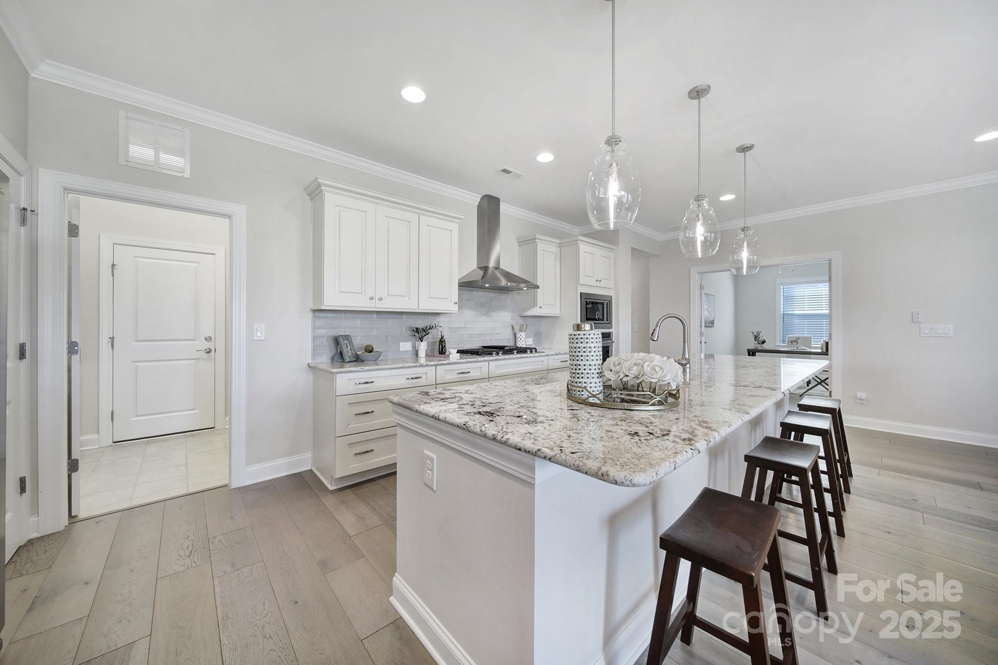 6255 Scuttle Lane, Unit 1104 Denver, NC 28037 - Photo 4 of 45 a kitchen with stainless steel appliances granite countertop a kitchen island a stove a table and chairs in it