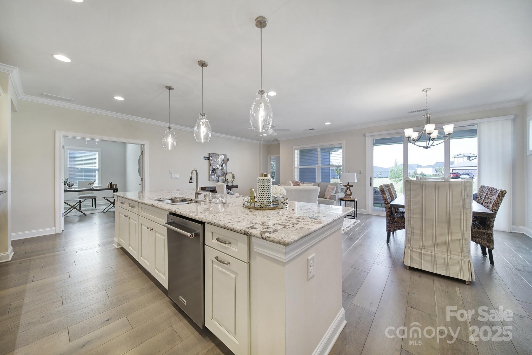 6255 Scuttle Lane, Unit 1104 Denver, NC 28037 - Photo 5 of 45 a large kitchen with kitchen island a sink table and chairs