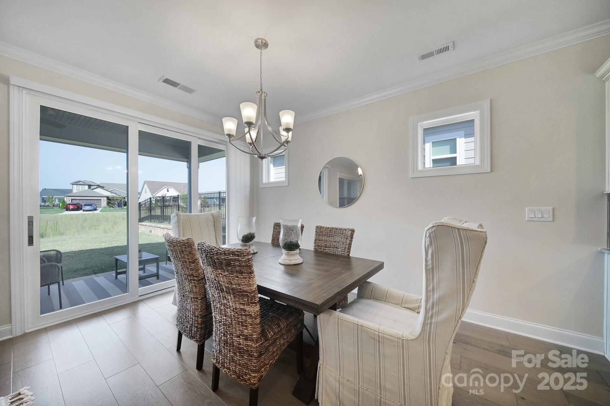 6255 Scuttle Lane, Unit 1104 Denver, NC 28037 - Photo 8 of 45 a view of a dining room with furniture wooden floor and chandelier