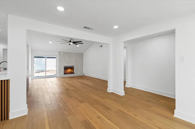 a view of empty room with wooden floor and fireplace