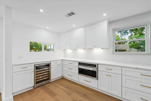 a kitchen with granite countertop white cabinets and white appliances