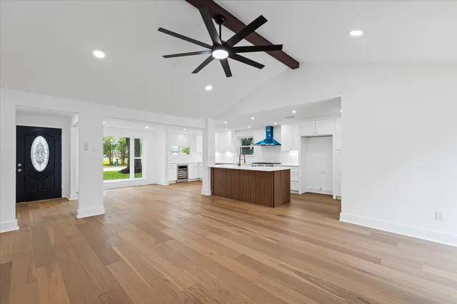 a view of an empty room with window and wooden floor