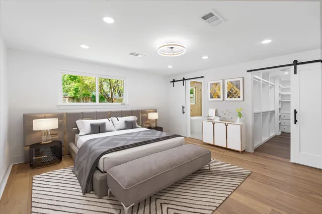 a bedroom with a large bed and a wooden floor